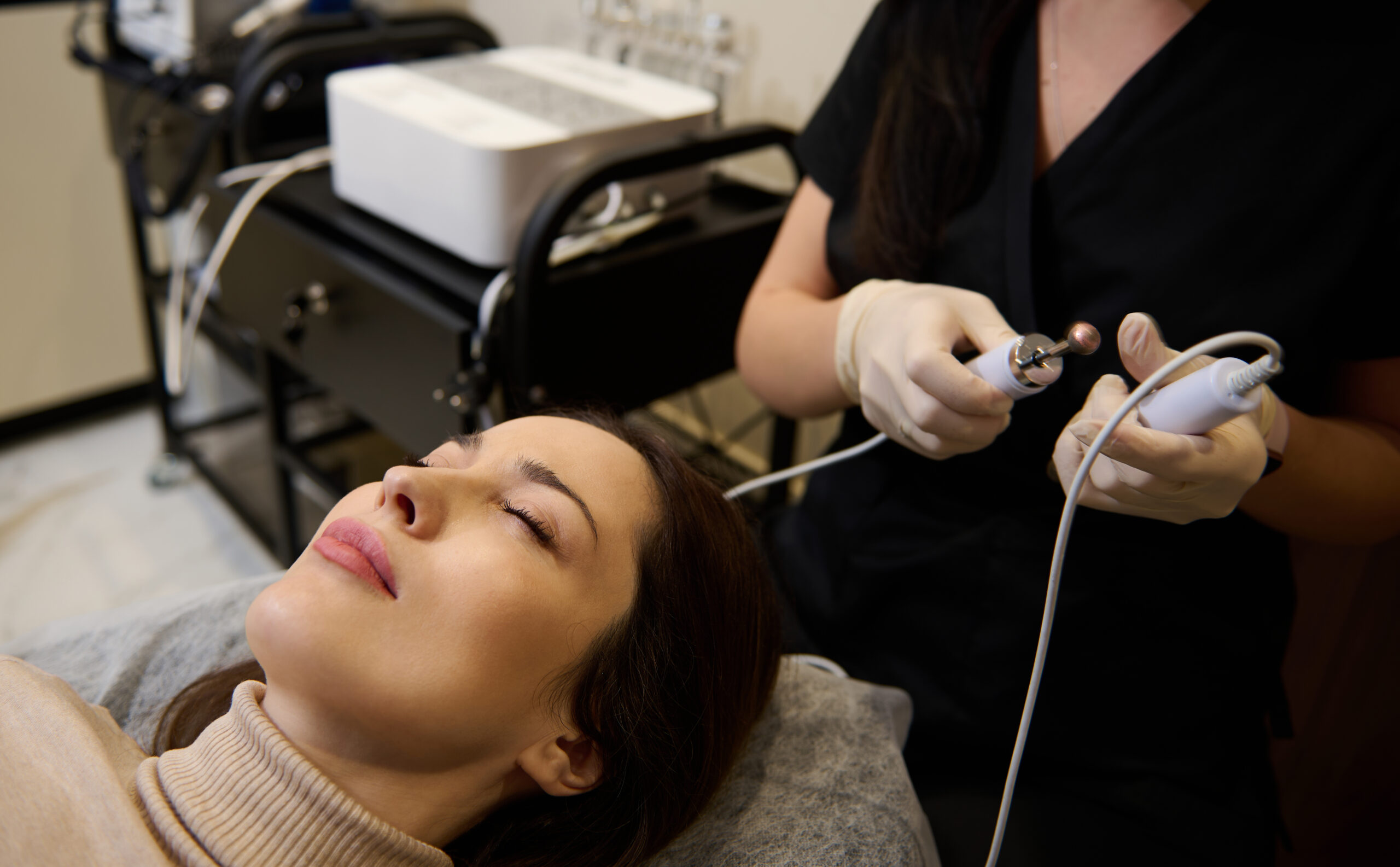 Beautiful young Hispanic woman at spa ready for getting professional cosmetological skin care and anti-aging treatment with electrical impulses on her face. Microcurrent rejuvenating therapy