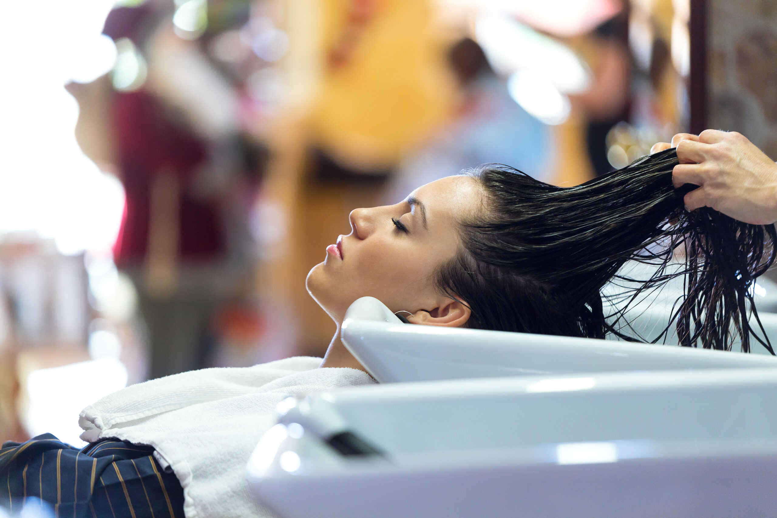 Portrait of beautiful young woman washes hair in a beauty salon.