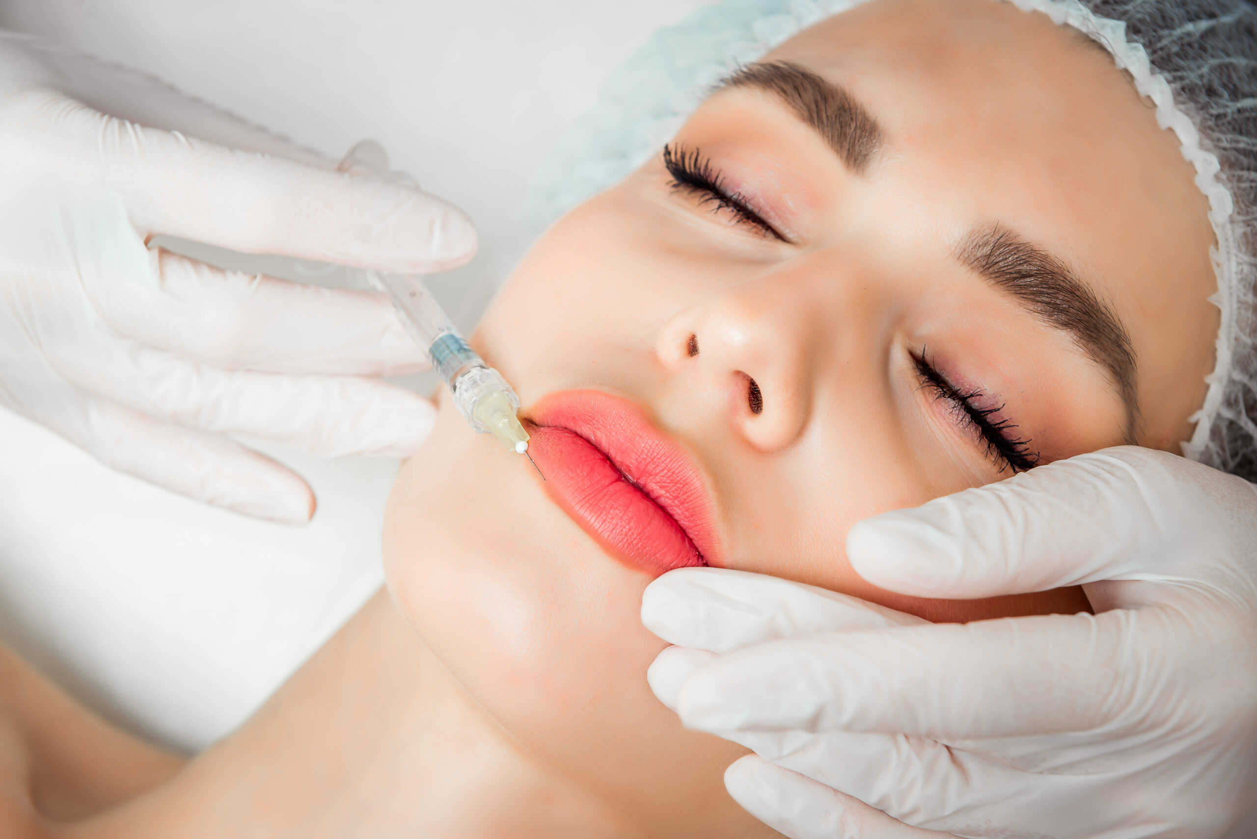 The doctor cosmetologist makes the Rejuvenating facial injections procedure for tightening and smoothing wrinkles on the face skin of a beautiful, young woman in a beauty salon.Cosmetology skin care.